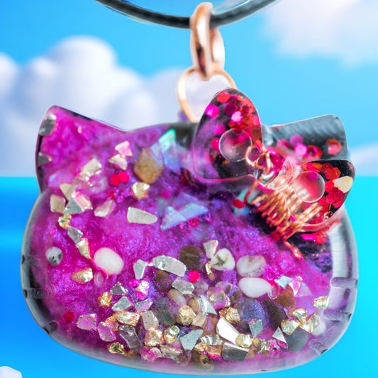 Colorful cat-shaped Pendant with glittery details against a blue sky background
