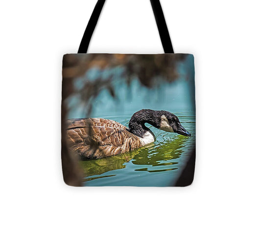 Goose Swimming in Tranquil Lake - Tote Bag